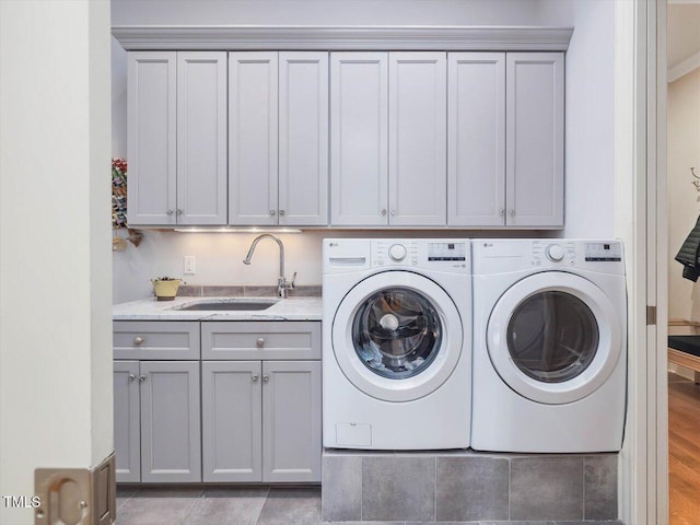 laundry room with washer and clothes dryer, cabinet space, and a sink