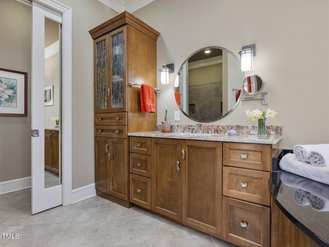 bathroom with baseboards, ornamental molding, vanity, and tile patterned flooring