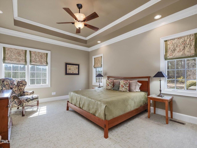 bedroom with baseboards, crown molding, a tray ceiling, and carpet