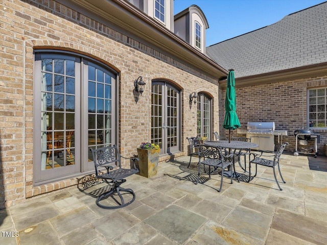 view of patio featuring outdoor dining space, french doors, and a grill