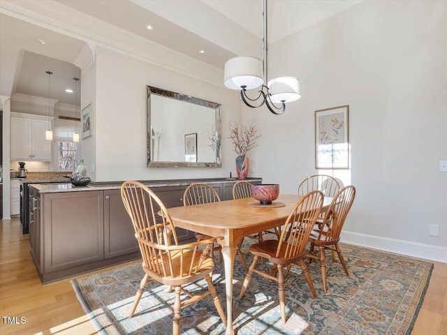 dining room with an inviting chandelier, crown molding, light wood-type flooring, and baseboards