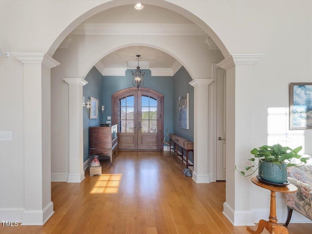 entrance foyer with french doors, baseboards, ornamental molding, and light wood finished floors