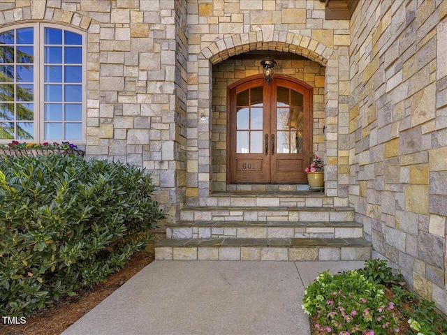 doorway to property featuring french doors and stone siding