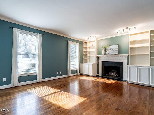 unfurnished living room featuring a fireplace, crown molding, baseboards, and wood finished floors