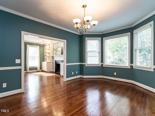 unfurnished room with dark wood finished floors, a notable chandelier, and a wealth of natural light