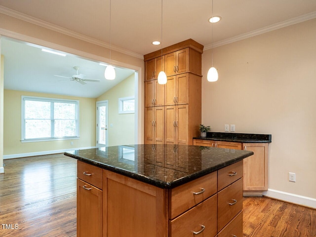 kitchen featuring decorative light fixtures, baseboards, wood finished floors, and crown molding