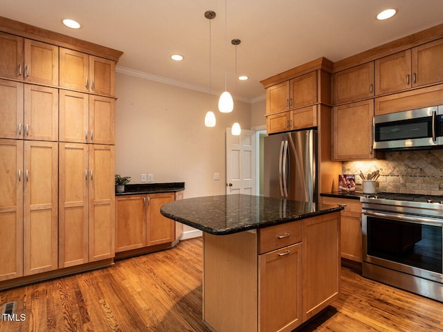 kitchen featuring decorative backsplash, light wood-style floors, a kitchen island, and stainless steel appliances