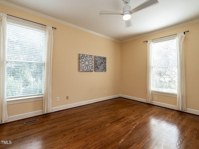 empty room with a healthy amount of sunlight, crown molding, and wood finished floors