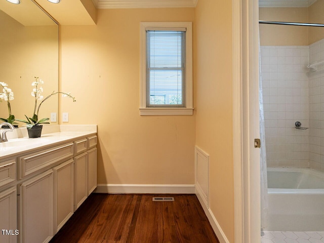 bathroom featuring visible vents, wood finished floors, washtub / shower combination, baseboards, and vanity