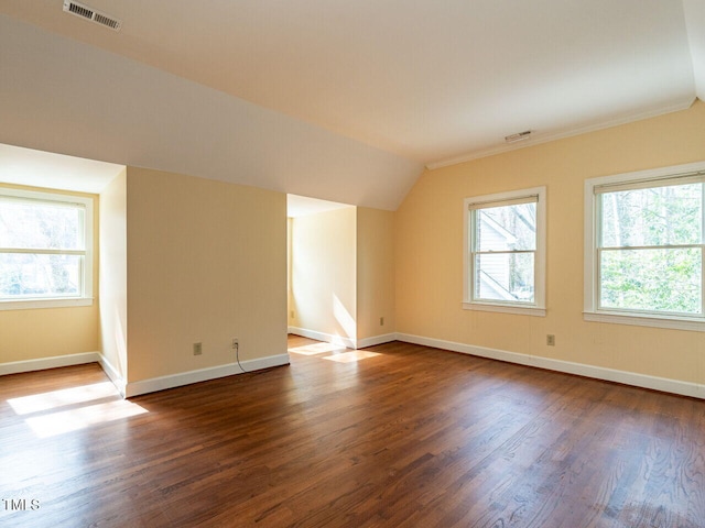 bonus room with visible vents, baseboards, dark wood-type flooring, and vaulted ceiling