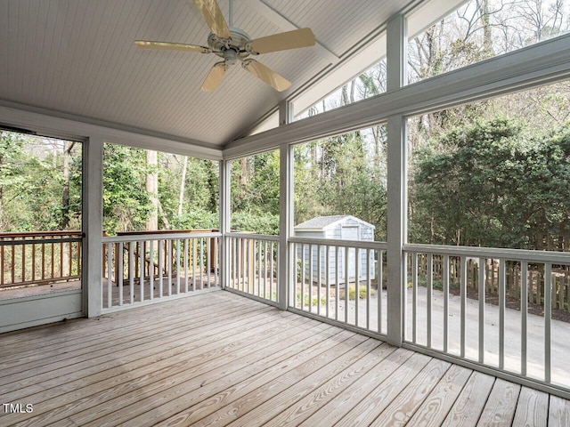 wooden terrace with a storage shed, an outdoor structure, and a ceiling fan