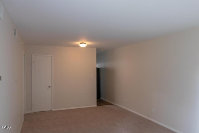 carpeted spare room featuring baseboards