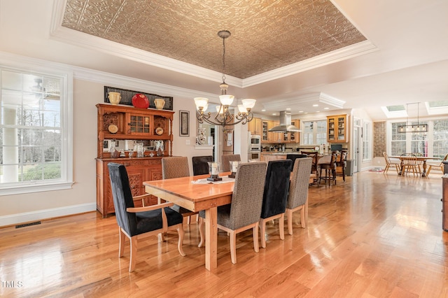 dining area with visible vents, a tray ceiling, an ornate ceiling, crown molding, and a chandelier