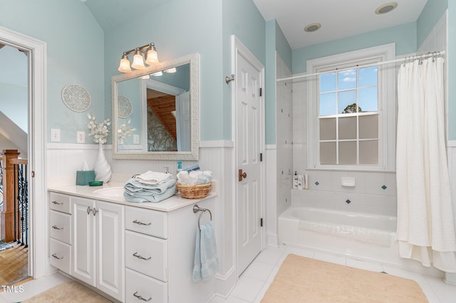 bathroom featuring tile patterned flooring, wainscoting, vanity, and shower / bathtub combination with curtain