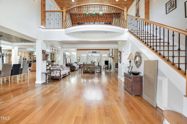 entryway featuring light wood finished floors, stairway, a high ceiling, and baseboards