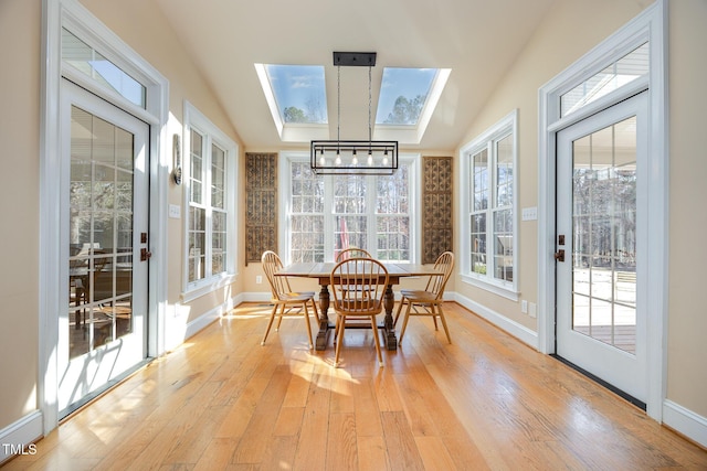 sunroom / solarium with vaulted ceiling with skylight