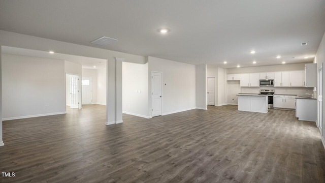 unfurnished living room with recessed lighting, visible vents, baseboards, and dark wood-style floors