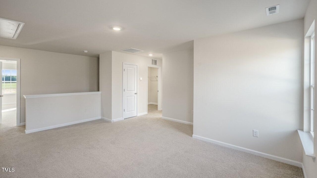 carpeted empty room featuring recessed lighting, visible vents, and baseboards