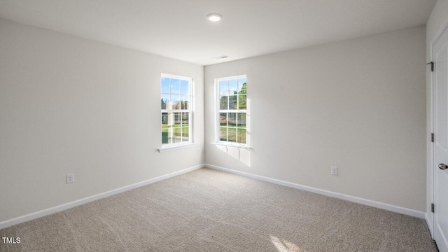 carpeted empty room featuring visible vents and baseboards