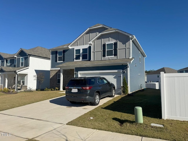 view of front of home with board and batten siding, fence, concrete driveway, a front yard, and an attached garage