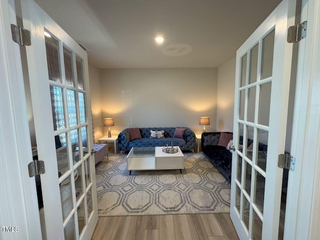 living area with wood finished floors and french doors