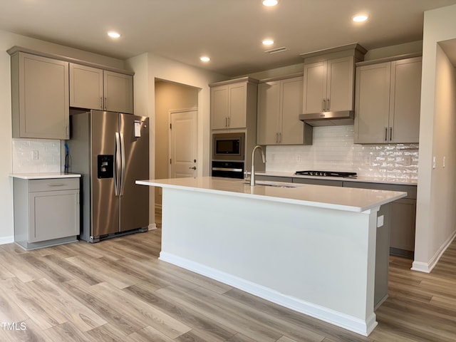 768 Riguard Way, Wendell, NC 27591 - kitchen with appliances with stainless steel finishes, a sink, gray cabinets, tasteful backsplash, and light wood-style flooring