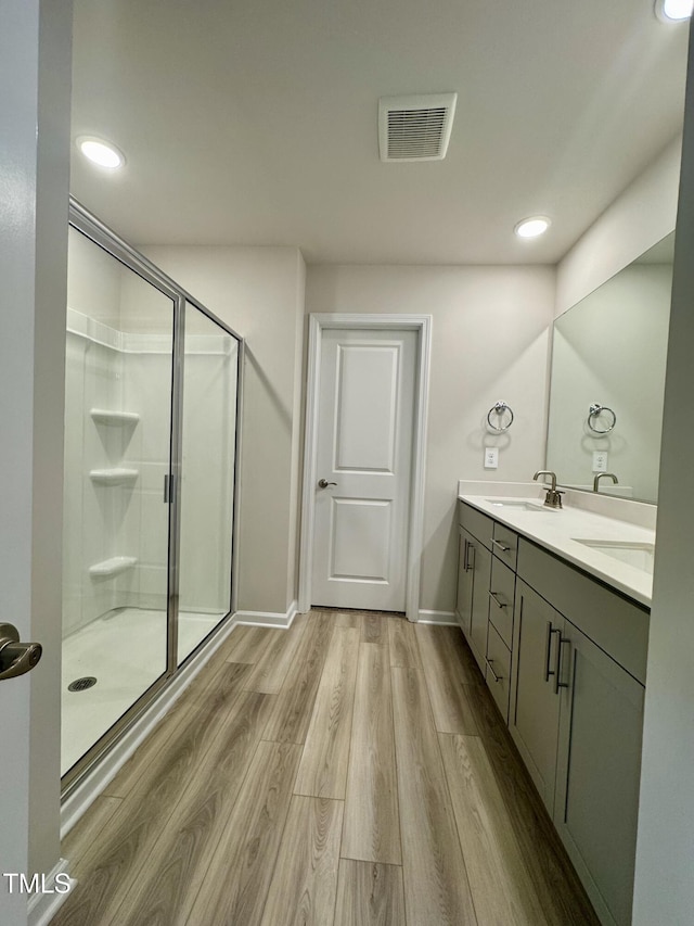 768 Riguard Way, Wendell, NC 27591 - bathroom with wood finished floors, a stall shower, double vanity, recessed lighting, and baseboards