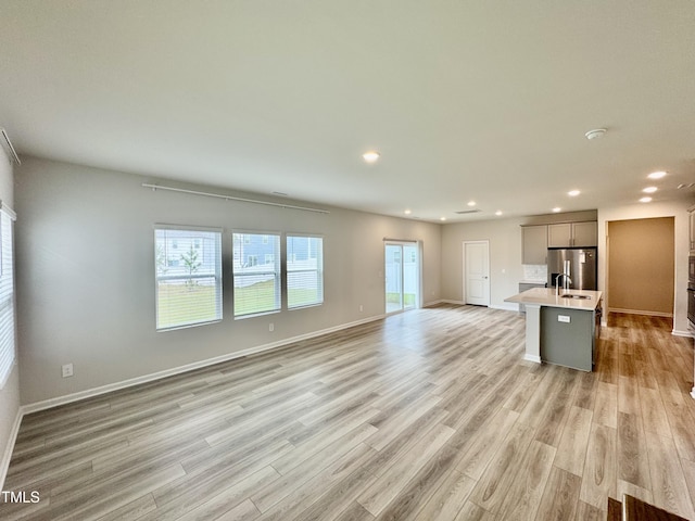 768 Riguard Way, Wendell, NC 27591 - kitchen with stainless steel fridge with ice dispenser, light wood-style flooring, open floor plan, recessed lighting, and light countertops