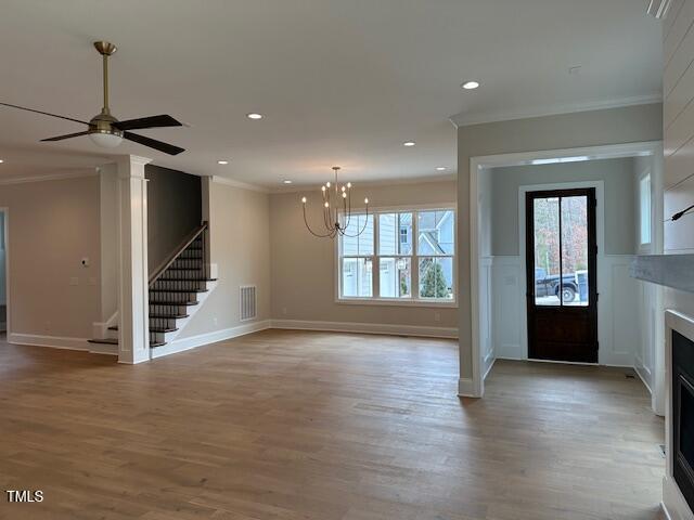 foyer entrance with visible vents, crown molding, a fireplace, and stairs