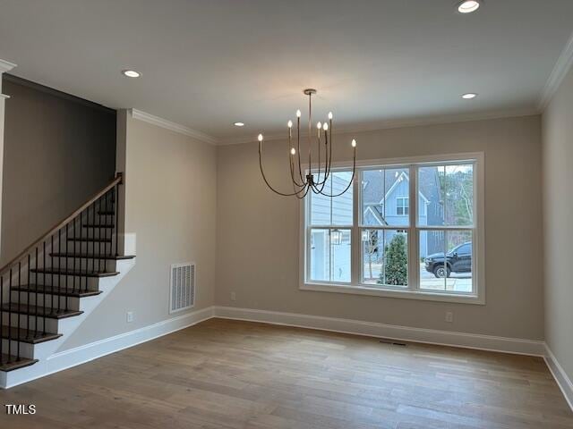 unfurnished dining area featuring crown molding, wood finished floors, baseboards, and visible vents