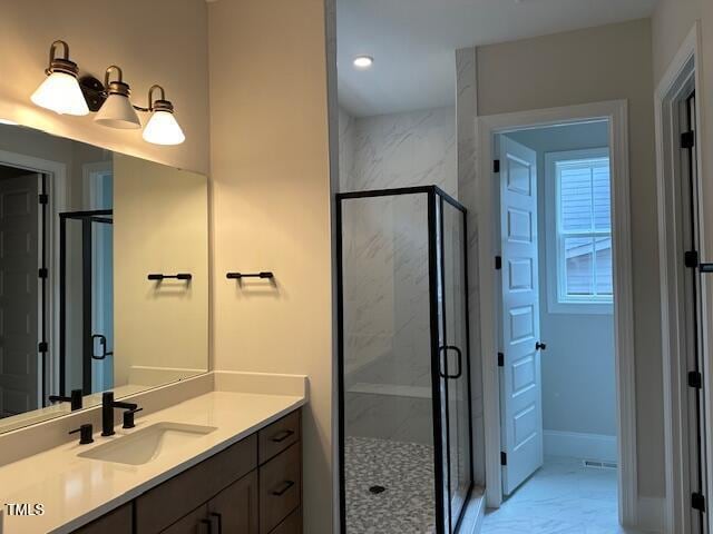 bathroom featuring vanity, baseboards, marble finish floor, and a marble finish shower