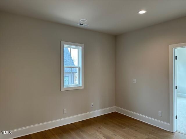 empty room featuring recessed lighting, visible vents, baseboards, and wood finished floors