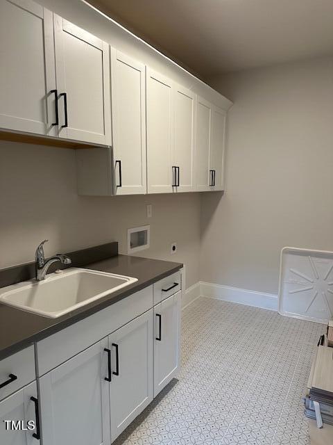 clothes washing area featuring electric dryer hookup, a sink, cabinet space, baseboards, and hookup for a washing machine