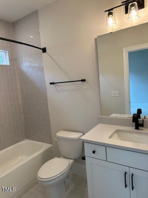 full bathroom with baseboards, toilet, vanity, and shower / tub combination