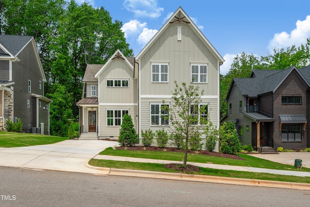 12912 Grey Willow Dr, Raleigh, NC 27613 - view of front of home featuring board and batten siding, cooling unit, a front lawn, and entry steps