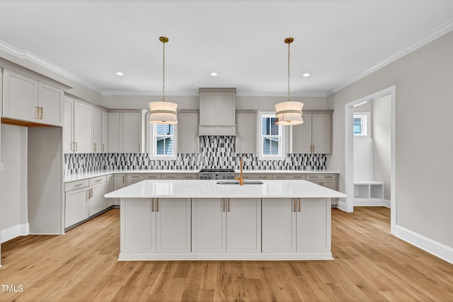 12912 Grey Willow Dr, Raleigh, NC 27613 - kitchen featuring gray cabinets, a sink, an island with sink, light countertops, and tasteful backsplash