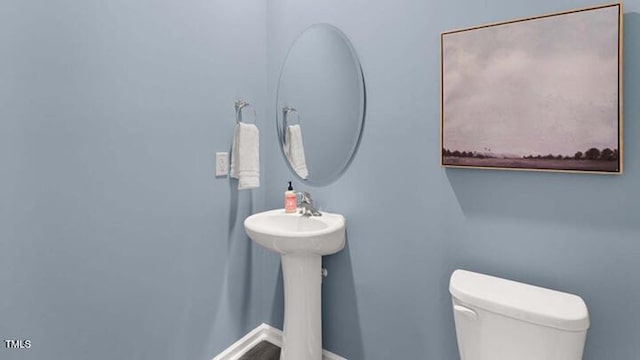 bathroom featuring toilet and baseboards