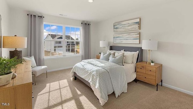 bedroom featuring baseboards and light carpet