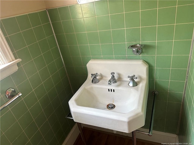 bathroom featuring tile walls and a sink