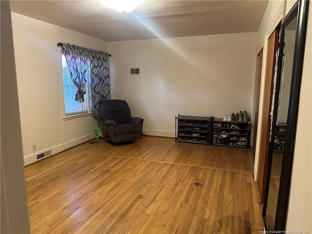 sitting room featuring visible vents, baseboards, and light wood-style floors