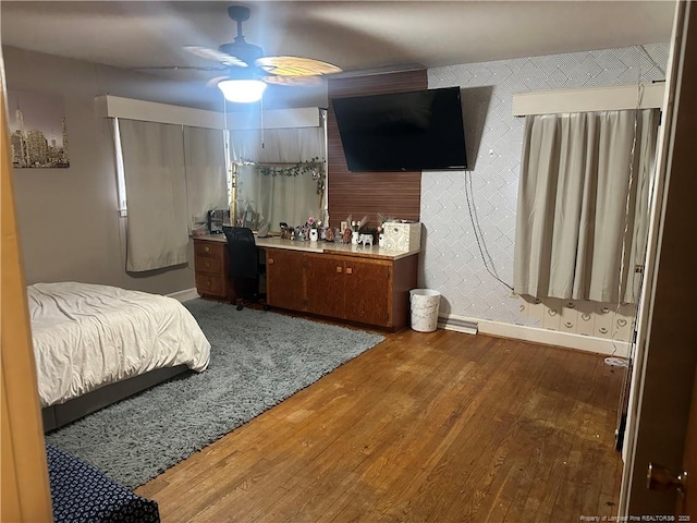 bedroom with wood finished floors, baseboards, and ceiling fan