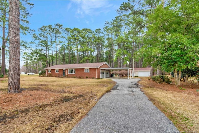 single story home with aphalt driveway, a garage, and a front yard