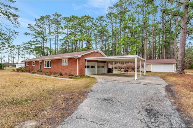 ranch-style house featuring aphalt driveway, an attached carport, brick siding, and a garage