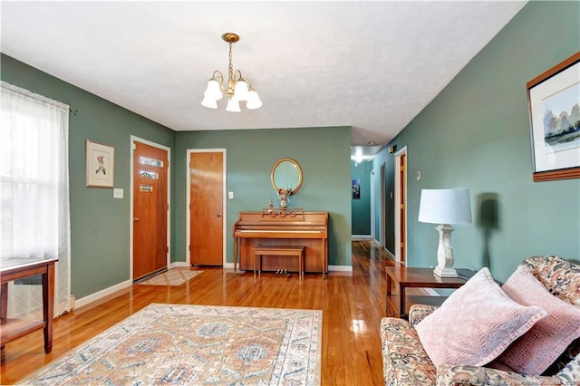 foyer entrance with baseboards, a notable chandelier, and wood finished floors