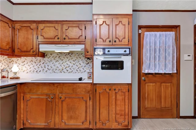 kitchen featuring under cabinet range hood, electric cooktop, brown cabinetry, white oven, and stainless steel dishwasher