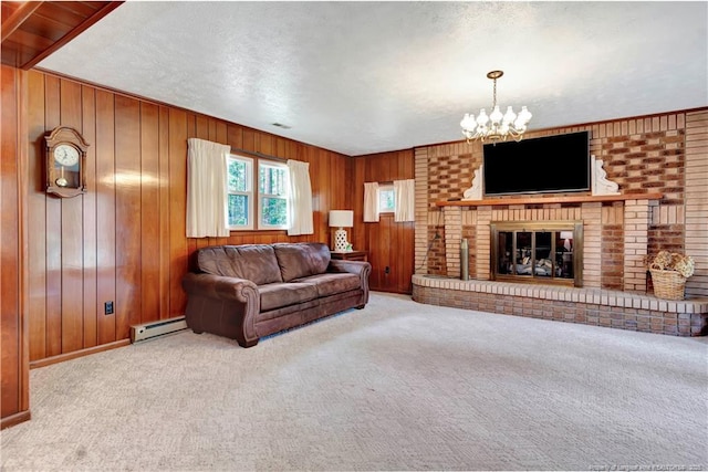 carpeted living area with a chandelier, wood walls, a brick fireplace, and a baseboard radiator