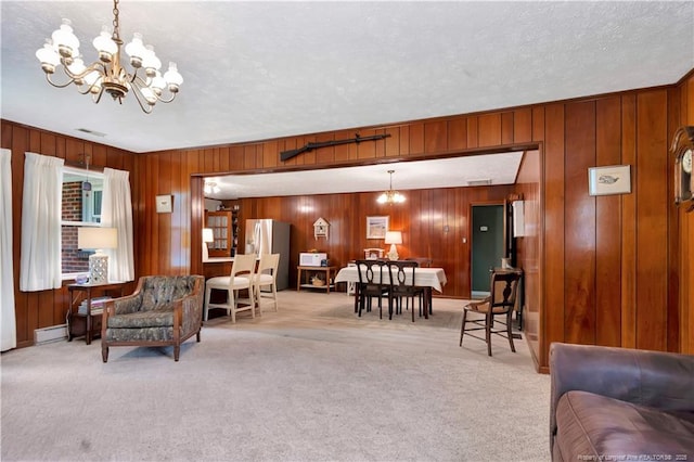 living area featuring a baseboard radiator, light colored carpet, a notable chandelier, and a textured ceiling