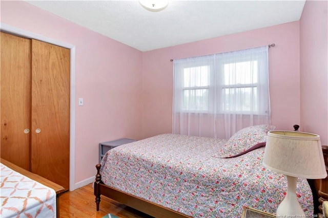 bedroom with baseboards and wood finished floors