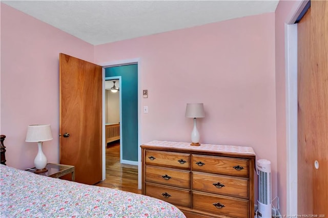 bedroom featuring baseboards and wood finished floors