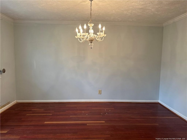 empty room featuring a notable chandelier, ornamental molding, baseboards, and wood finished floors